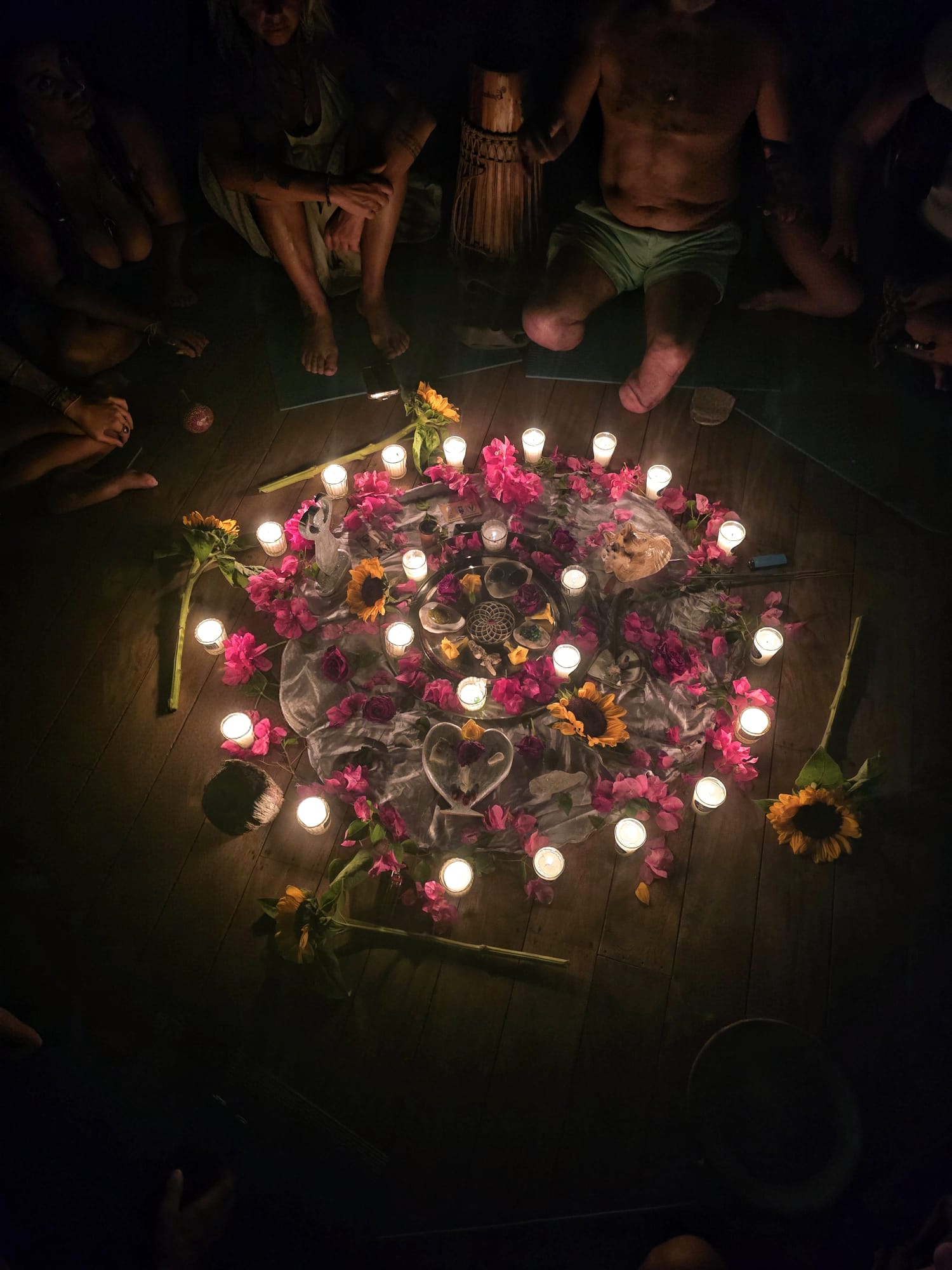An earth altar of flowers, candles, and natural offerings arranged in a circle
